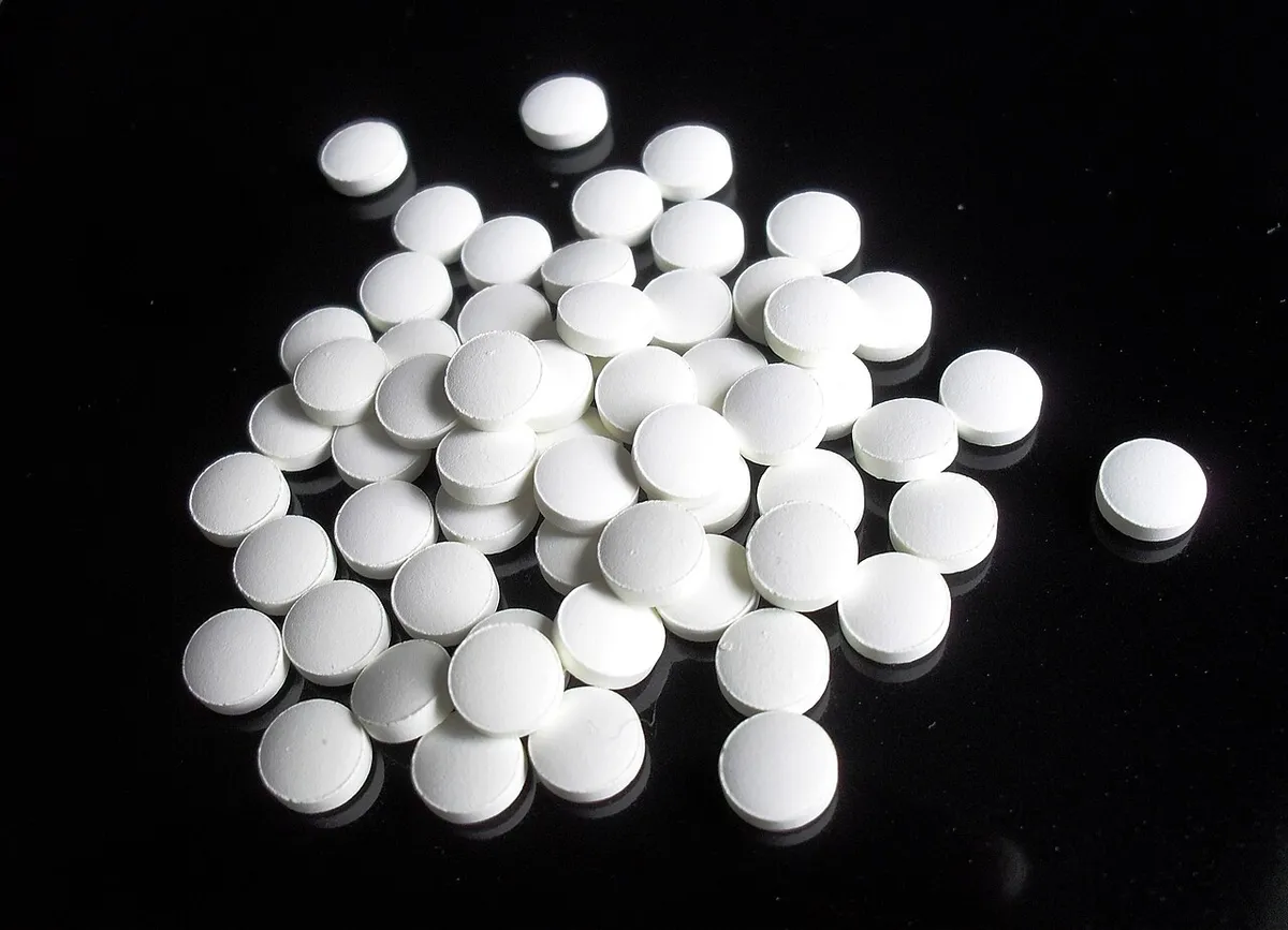 Compresse bianche di finasteride su sfondo nero